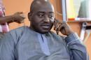 Liberia FA chairman Musa Bility speaks on his mobile phone on June 19, 2015, after annoucing plans to stand for the presidency of FIFA, in the Liberian capital Monrovia