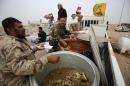 Iraqi men prepare food portions for Iraqi forces deployed in areas south of Mosul to battle Islamic State jihadists on October 28, 2016