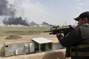 A member from the Iraqi security forces guards as smoke &hellip;