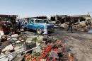 Residents gather at the site of car bomb attack in Rashidiya, a district north of Baghdad