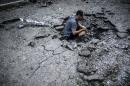 A man videos a shell crater in Donetsk, on July 29, 2014