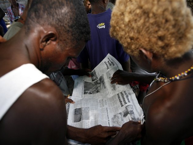 Dos residentes de las Islas Salomón leyendo el periódico. (AP/Rob Griffith)