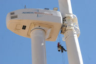 Above, rope technicians clean the blades of Fort Huachuca's newest wind turbine in southeast Arizona on March 15, 2011.