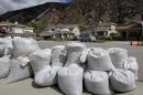 Sandbags line a steet considered especially at risk beneath a burned-over hillside in Azusa, Calif., as residents prepare for possible flooding Thursday, Feb. 27, 2014, in advance of a powerful Pacific storm. Mandatory evacuation orders have been issued for 1,000 homes in Glendora and Azusa, two of Los Angeles' eastern foothill suburbs which lie beneath nearly 2,000 acres of steep mountain slopes left bare by a January fire. (AP Photo/Reed Saxon)