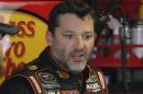 In this April 11, 2014, photo, Tony Stewart stands in the garage during practice for a NASCAR Sprint Cup series auto race at Darlington Speedway in Darlington, S.C. Authorities are investigating a serious crash that injured one person Saturday, Aug. 9, 2014, at a New York dirt track where Stewart was racing on the eve of a NASCAR race. (AP Photo/Mike McCarn)