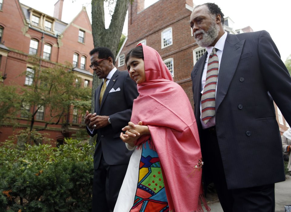 Director of the Harvard Foundation and Professor of Neurology at Harvard Medical School Dr. S. Allen Counter, left, escorts Malala Yousafzai, center, with a security guard, right, through Harvard Yard after a news conference on the Harvard University campus in Cambridge, Mass. on Friday, Sept. 27, 2013. The Pakistani teenager, an advocate for education for girls, survived a Taliban assassination attempt in 2012 on her way home from school. (AP Photo/Jessica Rinaldi)