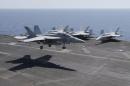 A F/A-18E/F Super Hornets of Strike Fighter Attack Squadron 211 (VFA-211) lands on the flight deck of the USS Theodore Roosevelt (CVN-71) aircraft carrier in the Gulf