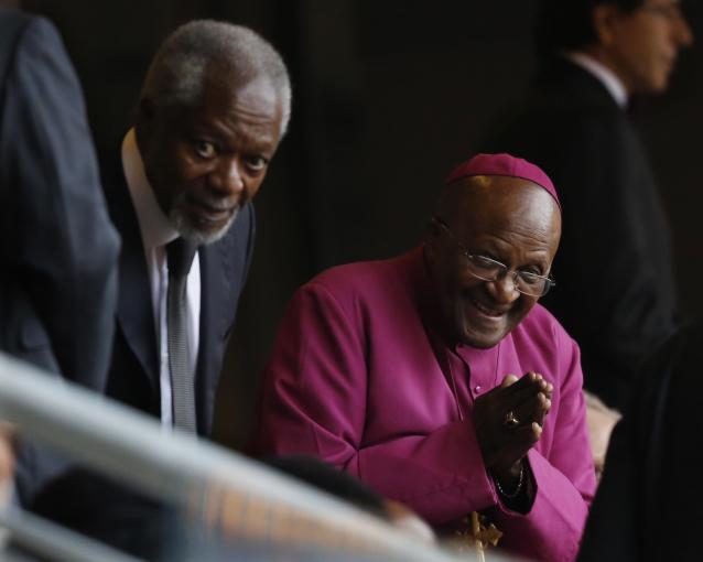 Retired Anglican Archbishop Desmond Tutu, right, arrives with Former U.N. Secretary-General Kofi Annan for the memorial service for former South African president Nelson Mandela at the FNB Stadium in the Johannesburg, South Africa township of Soweto, Tuesday Dec. 10, 2013. (AP Photo/Ben Curtis)