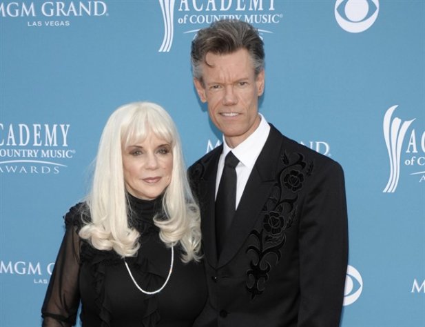 FILE - In this April 18, 2010 file photo, country singer Randy Travis, right, and then wife Elizabeth arrive at the 45th Annual Academy of Country Music Awards in Las Vegas. Travis has filed a countersuit against his ex-wife claiming she's been divulging confidential information about the country music singer that was calculated to damage his reputation and career. The court documents filed recently in a federal court in Nashville don't say what information Elizabeth Travis is alleged to have revealed. The filings are the latest salvo in the feud between the Travises. The couple divorced in 2010 after 19 years of marriage. Elizabeth Travis had been his manager for more than three decades. She sued him last month claiming that Randy Travis made it impossible for her to do her job and terminated her management contract without proper written notice. (AP Photo/Dan Steinberg, file)