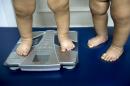 Colombian twins are weighed in a nutritionist's office on September 22, 2011 in Medellin, Colombia