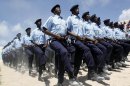 FILE - In this July 1, 2013, file photo, Somali policemen march during the Somalia's Independence Day, at Konis stadium in Mogadishu, marking 53 years since the Southern regions of Somalia gained independence from Italy and joined with the Northern region of Somaliland to create Somalia. Twenty years after the U.S. military's "Black Hawk Down" disaster, the Obama administration is slowly stepping up relations with Somalia even though security requires American officials to be sheltered behind blast walls and unable to see nearly any of the chaotic country. (AP Photo/Farah Abdi Warsameh, File)