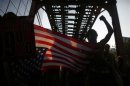 Protesters holding an American flag march over a bridge during an anti-NATO protest march in Chicago