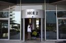 A worker cleans beneath the logo of Nice Systems at the entrance of its headquarters in Raanana