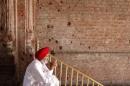 A Sikh man sits beside the wall of one of the complex of Golden Temple hit by the bullet shots in Amritsar