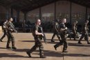 French soldiers walk past a hangar they are staying at the Malian army air base in Bamako