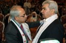 Syrian regime opponent Riad Seif, right, shakes hands with Syrian National Council (SNC) chief Abdel Basset Seda during the meeting of the General Assembly of the Syrian National Council in Doha, Qatar, Tuesday, Nov. 6, 2012. (AP Photo/Osama Faisal)