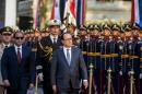 Egyptian President Abdelfattah al-Sisi and his French counterpart Francois Hollande review the honour guard during a welcome ceremony at the al-Quba presidential palace in Cairo on April 17, 2016