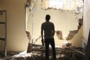 A man inspects damage at a hospital in Deir al-Zor
