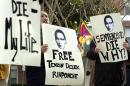 Protestors hold signs calling for the release of jailed Tibetan Buddhist teacher Tenzin Delek Rinpoche
