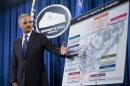 FILE - This Sept. 26, 2013 file photo shows Attorney General Eric Holder pointing to an illustrations of the auto parts during a news conference at the Justice Department in Washington. A federal investigation into price fixing in the auto parts industry, made public four years ago with FBI raids in the Detroit area, has mushroomed into the largest antitrust investigation in Justice Department history _ and authorities say it's not over yet. (AP Photo/Manuel Balce Ceneta, File)
