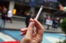 A woman is seen smoking a cigarette at the Times Square in New York, on May 23, 2011