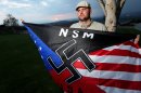 FILE - In this Oct. 22, 2010 file photo, Jeff Hall, who was killed by his son, holds a Neo Nazi flag while standing at Sycamore Highlands Park near his home in Riverside, Calif. Defense attorneys for a boy charged with killing Hall, his neo-Nazi father when he was 10 years old has rested its case without calling the boy to testify, Wednesday, Jan. 9, 2013. (AP Photo/Sandy Huffaker, File)