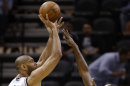 Tim Duncan, de los Spurs de San Antonio, dispara sobre la marca de Paul Millsap, del Jazz de Utah, durante la primera mitad del partido del viernes 22 de marzo de 2013, en San Antonio. (Foto AP/Darren Abate)