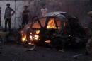 A car burns at the site of a car bomb attack outside the house of the director of security for Yemen's southern port city of Aden Brigadier General Shalal Ali Shayyeh in Aden