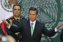 Mexico's President Pena Nieto gestures before he signs into law a radical reform of the country's energy, at the National Palace in Mexico City