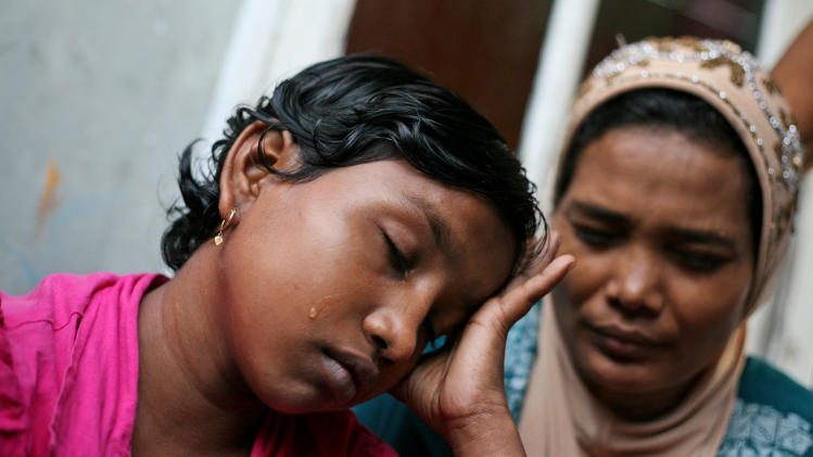 In this Oct. 19, 2013 photo, young ethnic Rohingya asylum seeker Senwara Begum, left, cries at a temporary shelter in Medan, North Sumatra, Indonesia after making a phone call to her family in Myanmar. After her tiny Muslim village in Myanmar&#39;s northwest Rakhine had been destroyed in a fire set by an angry Buddhist mob, she and her brother became separated from their family. (AP Photo/Binsar Bakkara)