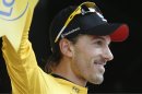 Fabian Cancellara of Switzerland, wearing the overall leader's yellow jersey, celebrates on the podium after winning the prologue of the Tour de France cycling race, an individual time trial over 6,4 kilometers (4 miles) with start and finish in Liege, Belgium, Saturday June 30 2012. (AP Photo/Laurent Rebours)