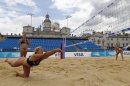 Britain's beach volleyball team member, Denise Johns dives for the ball as teammate, Lucy Boulton, left, opposition Shauna Mullin and Zara Dampney, right, look on as they try-out the arena during a photocall at Horse Guards Parade in London on the eve of the FIVB Beach Volley International Olympic test event tournament, Monday, Aug. 8, 2011. Horse Guards Parade will host the London 2012 Olympic beach volley competition next year. (AP Photo/Sang Tan, file)