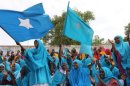 Somali women wave their national flag in Mogadishu during a ceremony marking the anniversary of Somalia's independence