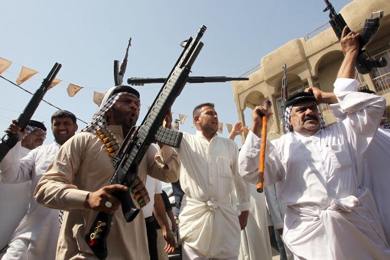 Iraqi men carry their weapons as they volunteer to fight along side the Iraqi security forces against Jihadist militants, on June 14, 2014, in Baghdad