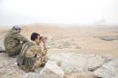 Forces loyal to Syria's President Bashar al-Assad take positions on a look-out point overlooking the historic city of Palmyra in Homs Governorate