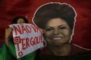 Woman shows poster written in Portuguese "There will not be a coup" next to a picture of Brazil's President Dilma Rousseff, during a rally in her support and of former President Luiz Inacio Lula da Silva, in Brasilia, Brazil, Friday, March 18, 2016. Supporters of Silva and Rousseff gathered for rallies in a handful of cities across Brazil, particularly in the industrial south, where the former factory worker has his base. Silva has been tied to a sprawling corruption investigation involving the Brazil oil giant Petrobras. (AP Photo/Eraldo Peres)