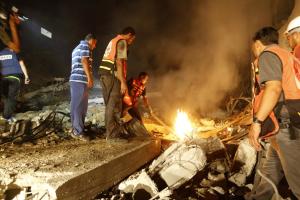 Palestinian rescuers clear the rubble of a destroyed &hellip;