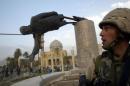 A U.S. MARINE WATCHES A STATUE OF PRESIDENT SADDAM HUSSEIN FALL IN CENTRAL BAGHDAD.