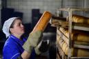 A worker stacks loaves of bread in a factory in Debaltseve, Ukraine, on March 9, 2015