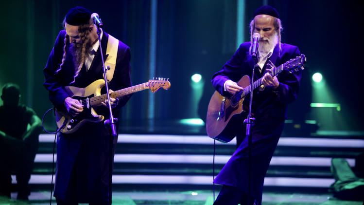 In this photo taken Oct. 22, 2013, Ultra-Orthodox Jewish singers Arie Gat, right, and his brother Gil, perform as they participate in an Israeli tv show in Neve Ilan, Jerusalem. For most Israelis, the common perception of the ultra-Orthodox Jewish minority is that of an insulated, segregated society devoted to studying ancient biblical texts and rejecting the ills of secular life. But the pair of devout, soft-spoken brothers in skullcaps and sidecurls are now breaking down some stereotypes by emerging as the most unlikely of media darlings _ reality rock stars. (AP Photo/Dan Balilty)