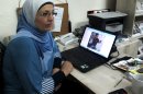 In this photo taken Wednesday, Aug. 29, 2012, Hekmat Besesso, a Palestinian woman's rights advocate, sits beside a laptop that shows an image of her son, Yazan, 6, in the West Bank city of Ramallah. Besesso, a divorce, lost custody of her son after she remarried _ a quirk of Palestinian law. Now, she says, her husband wont let her see him once a week, in accordance with her visitation rights. (AP Photo/Diaa Hadid)