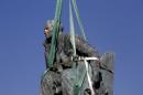 The statue of Cecil John Rhodes is bound by straps as it awaits removal from the University of Cape Town