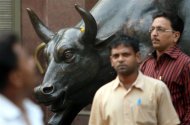 People walk past a bronze replica of a bull at the Bombay Stock Exchange (BSE) building in Mumbai November 3, 2008. REUTERS/Punit Paranjpe/Files