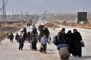Syrian families freel from eastern Aleppo November 29, 2016 in Jabal Badro, as they walk towards government-controlled western Aleppo, as the Syrian government offensive to recapture rebel-held Aleppo continues