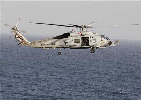A Sikorsky SH-60 Seahawk helicopter flies near the Nimitz-class aircraft carrier USS Abraham Lincoln (CVN 72) during a transit through the Strait of Hormuz, in this February 14, 2012, file photo. REUTERS/Jumana El Heloueh/Files