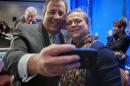 New Jersey Gov. Chris Christie takes a cell phone photo with NGA staffer Lily Kersh during the National Governor's Association Winter Meeting in Washington, Saturday, Feb. 22, 2014. (AP Photo/Cliff Owen)