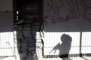 The shadow of a Free Syrian Army fighter is cast on a wall of a school in Sheikh Maksoud area in Aleppo