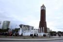 People sit in front of the clock tower at the end of Avenue Habib Bourguiba in Tunis