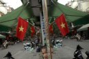 A Vietnamese boy is reflected in a mirror along a street decorated with national flags, in downtown Hanoi