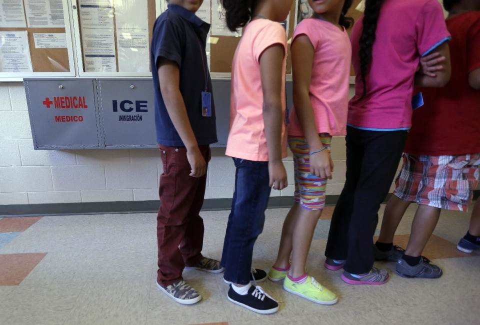 FILE - In this Sept. 10, 2014 file photo, detained immigrant children line up in the cafeteria at the  Karnes County Residential Center,  a temporary ...